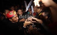 Jokowi menyalami warga yang mengerubutinya.