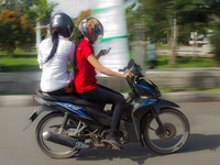 Naik motornya sih sudah tertib, keduanya pake helm. Tapi kenapa keselamatannya diabaikan hanya untuk membaca sebuah sms. (Foto: N. Hadiyanto).