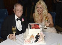 Hugh dan Crystal berpose dengan kue pernikahan mereka yang lengkap ada foto keduanya di atas kue tersebut. Reuters/Elayne Lodge.