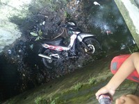 Motor yang terjatuh ke parit jadi tontonan warga. (Foto Tatang Sofyan)