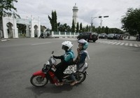 Perempuan Aceh melintas di dekat Masjid Baiturrahman, Banda Aceh, Kamis (3/13). Larangan perempuan duduk ngangkang saat dibonceng sepeda motor menuai protes. REUTERS/Junaidi Hanafiah.