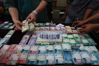 Polisi mengelar barang bukti uang senilai Rp 300 juta dan USD 30 ribu hasil tangkapan dari pengedar narkoba di Halaman Polres Jakarta Barat, Jakarta, Jumat (4/13).