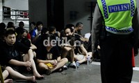 Polisi menjaga 81 orang tahanan WNA yang berhasil dievakuasi dari gedung Kemenkum HAM.