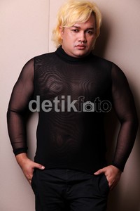 Pria berambut pirang itu berpose di depan kamera.