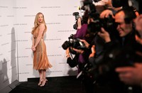 Ia mengenakan dress rancangan Bottega Veneta, high heels Alexandre Birman, dan anting Norman Silverman. Stephen Lovekin/Getty Images.