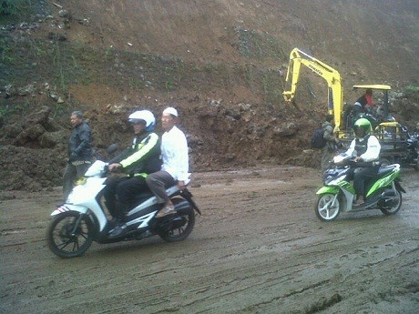 Polisi Bantu Warga Lewati Longsor di Puncak dengan Motor