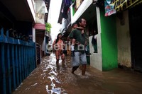 Seorang siswa berangkat sekolah dengan digendong ayahnya.