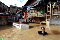 Banjir dimanfaatkan sebagian anak untuk bermain air.