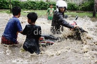 Dua bocah membantu mendorong sepeda motor yang mogok. Ramses/detikfoto     