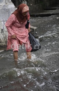 Seorang nenek menyeberang digenangan air setingi 60 cm. Ramses/detikfoto     