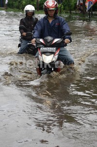 Dua pengedara motor berusaha menerobos genangan air yang tinggi mencapai 60 cm. Ramses/detikfoto