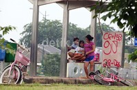 Warga yang bersepeda melintas digenangan air yang telah diguyur hujan deras, dijalur sepeda Banjir Kanal Timur (BKT), Jakarta, Minggu (13/01).