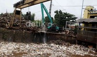 Sampah yang terbawa arus Sungai Ciliwung dan berasal dari rumah-rumah warga ini, diangkut petugas dengan menggunakan alat berat Excavator dari DPU DKI Jakarta.