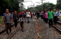 Para penumpang berjalan kaki dari Stasiun UI ke Stasiun Pondok Cina.