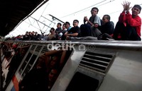 Para penumpang menaiki kereta dengan tujuan masing-masing.