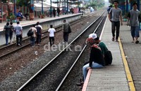 Sebagian calon penumpang menunggu kereta dengan duduk-duduk di peron Stasiun Pondok Cina.
