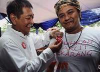 Deddy Mizwar menyematkan kancing bereum yang menjadi simbol pasangan Aher-Deddy untuk Jabar 2013-2018.