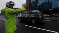 Polisi mengatur arus lalu lintas.