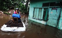 Sejumlah warga mengunakan rakit sederhana mengunggsi ketempat yang lebih tinggi.     