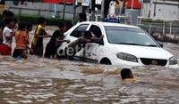 Anak-anak membantu mendorong taksi yang mogok.