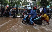 Dua orang anak membantu mendorong motor yang mogok.
