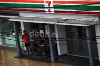 Karyawan 7 Eleven memilih berjaga di depan toko mereka.