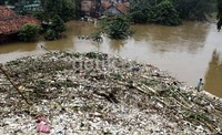 Gunungan sampah didominasi kayu, sterofoam, dan batang pohon.