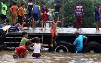 Anak-anak bermain di saat banjir.