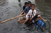 Menyelusuri banjir dengan perahu rakitan.