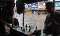 2 Warga memilih bermain catur saat banjir menerjang.