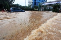 Beberapa warga membantu mendorong mobil yang mogok.
