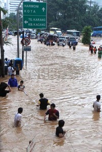 Dengan berpegangan tambang, warga melintasi banjir setinggi dada orang dewasa.