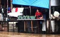 Seorang warga menunggu banjir surut di lantai 2 rumahnya.