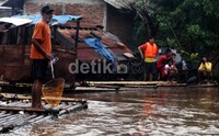 Banjir dimanfaatkan sebagian warga untuk mencari ikan.