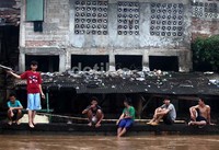Sejumlah anak asyik menonton banjir yang menggenagi sekitar rumahnya.