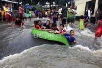 Banjir dimanfaatkan sejumlah anak untuk bermain.
