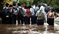 Di tengah banjir, mereka justru berfoto ria.