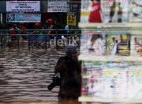 Banjir sepaha, seorang fotografer rela basah-basahkan untuk mendapatkan gambar terbaik.