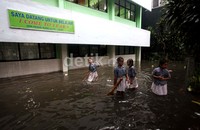 Sejumlah siswa bermain air di halaman sekolah.