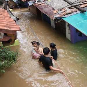 Sambil Menggendong Anak, Warga Kampung Melayu Menembus Derasnya Banjir