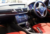 Interior X1. Di bagian interior, terdapat tempat duduk model sports dari bahan kulit Nevada, roda kemudi serta tuas verseneling berbalut kulit dengan jahitan warna merah, trim interior Black high-gloss, karpet dengan piping warna merah.
