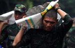 Prajurit TNI Panggul Batu untuk Bendung Banjir