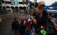 Warga menumpang truk untuk menyeberangi banjir.