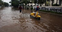 Sebuah sepeda motor mogok setelah nekat menerobos banjir.