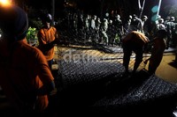 Proses perbaikan tanggul terkesan lambat dikarenakan lokasinya yang becek dan hujan yang terus menerus menguyur.