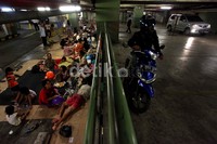 Para pengungsi duduk-duduk di parkiran mobil West Mall Grand Indonesia.