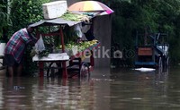 Meski banjir, pedagang sayur tetap jualan.