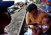 Warga mengungsi di rel kereta api di sekitar Stasiun Pesing.
