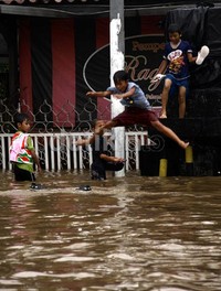Anak-anak asyik 'lompat indah' seakan lokasi banjir kolam renang. Ramses/detikFoto.