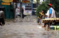 Orang dewasa pun tak mau ketinggalan, mereka memanfaatkan banjir untuk bermain bola.